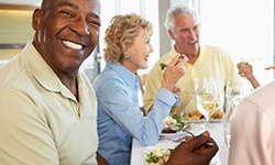 Patient in Casper with dentures smiling with friends