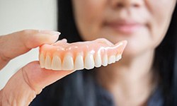 Woman holding dentures